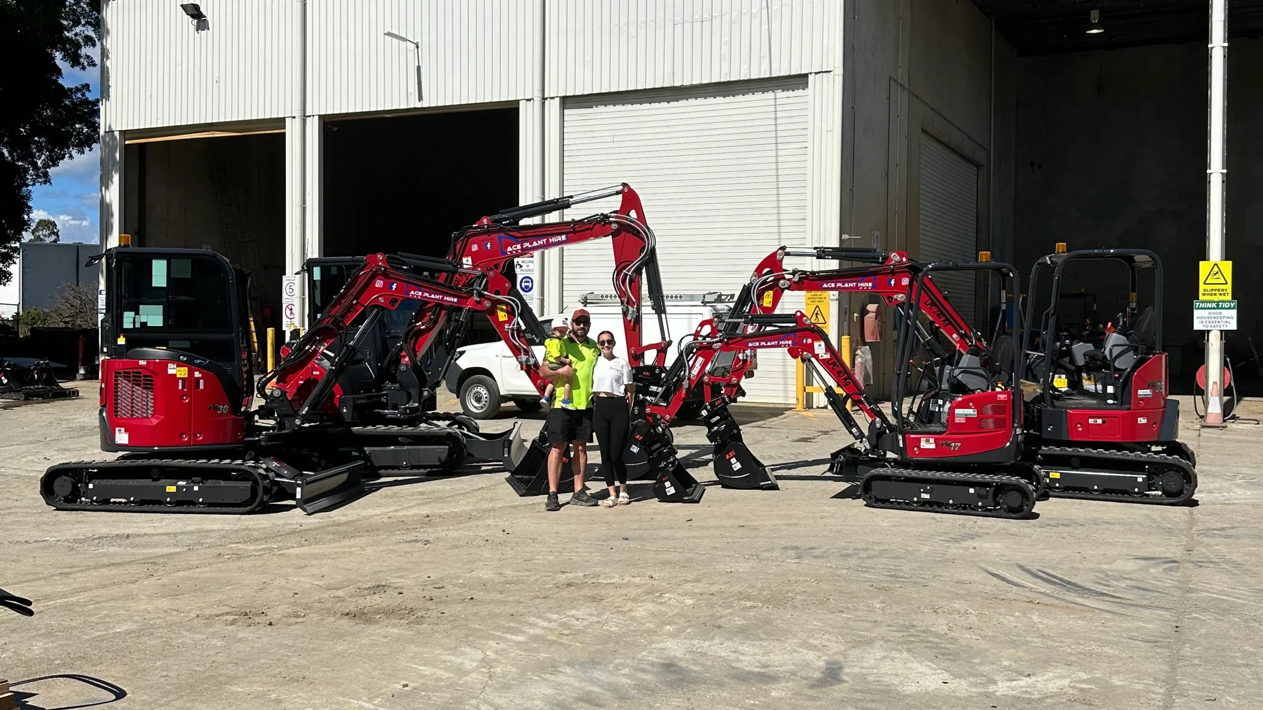 Ace Plant Hire team with red mini excavators at Brisbane depot