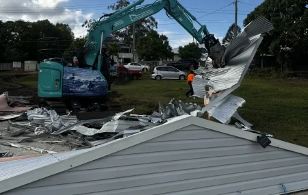 Ace Plant Hire excavator using a demolition attachment to tear down a metal shed roof on site